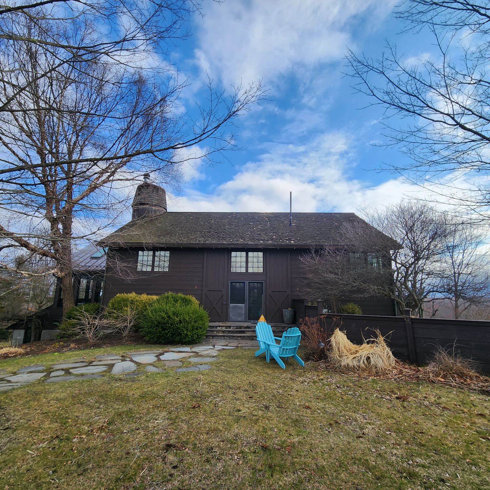Weathered cedar shake roof on a barn home before replacement