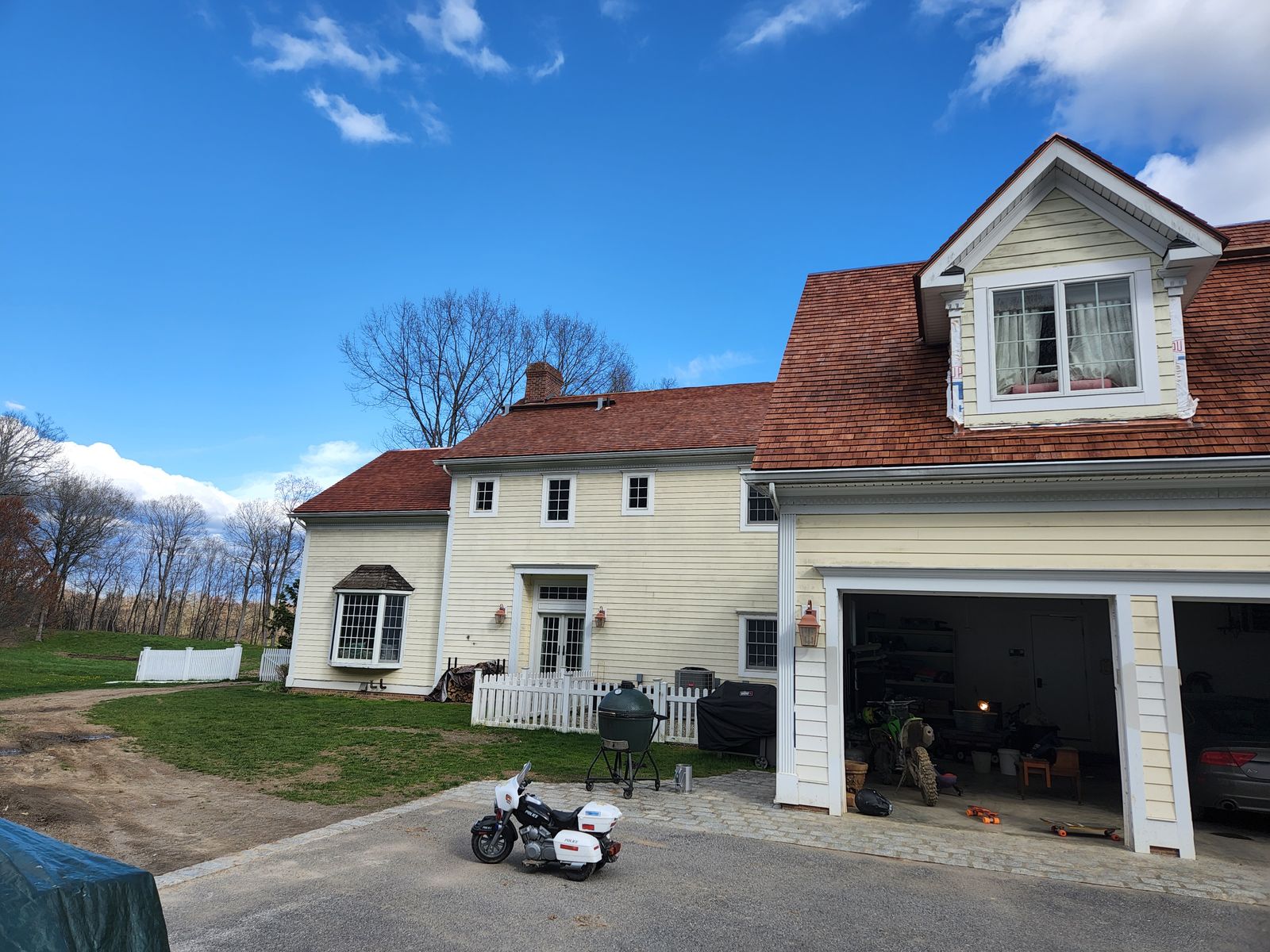 New cedar shake roof on a yellow colonial home