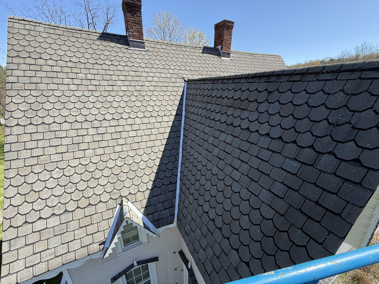 Home with a GAF Camelot designer shingle roof, one plane newly replaced beside the weathered original