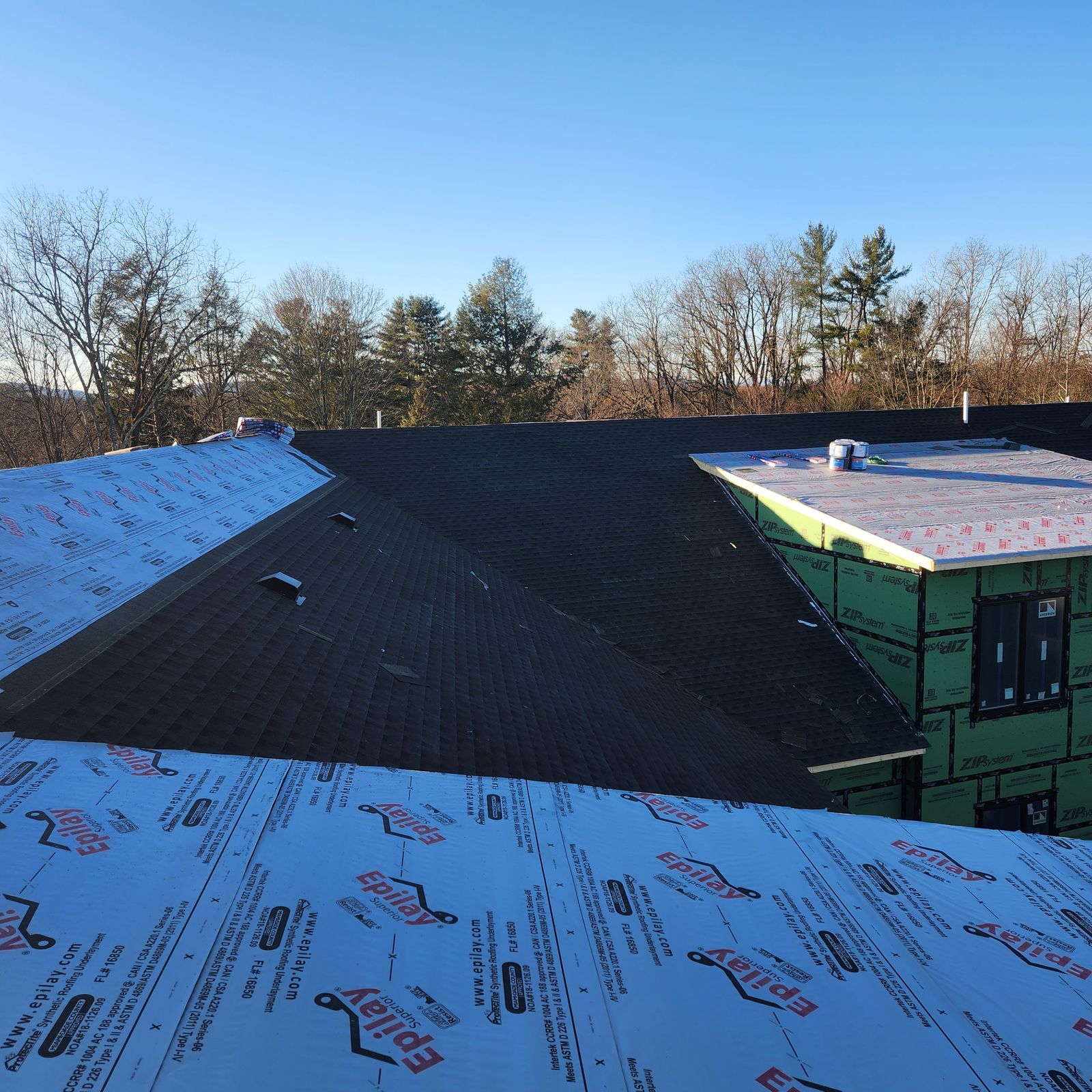 Completed shingle roof on new construction with dormers and synthetic underlayment
