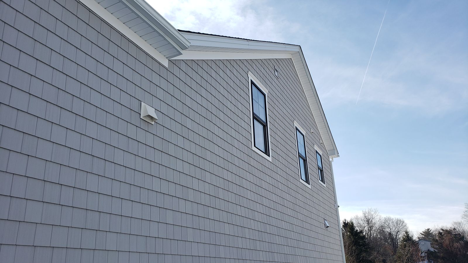 Close view of shake siding with clean soffit, fascia and gutter line