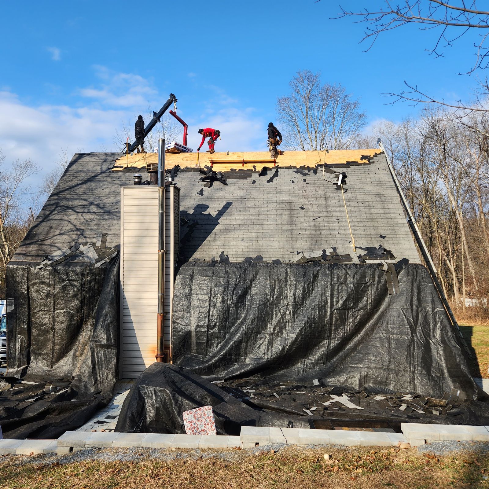 Roof tear-off with the entire house wrapped in protective tarps