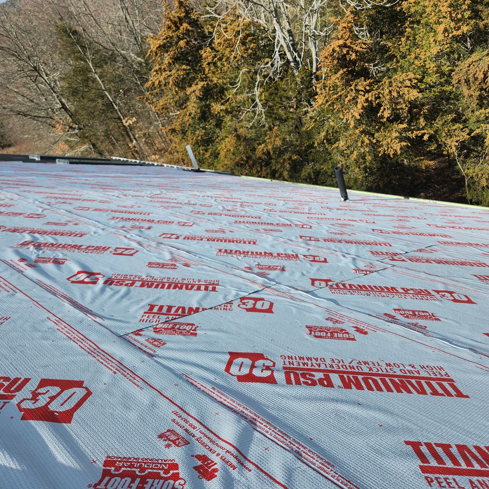 Peel and stick high temperature underlayment covering an entire roof deck